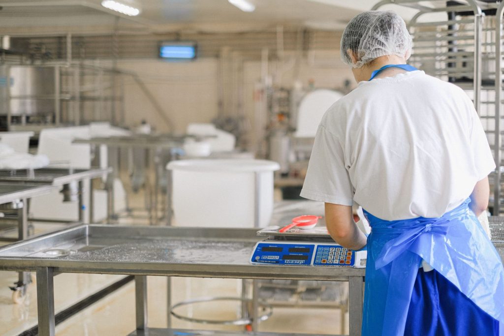 Operaria con gorro y delantal trabajando en un obrador alimentario